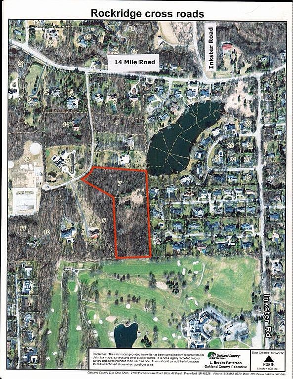 This is an aerial view of a residential area, featuring a mix of houses, roads, a lake, and a golf course. The image highlights property boundaries, with one particular parcel outlined in red. The overall impression is of a well-developed suburban neighborhood with recreational amenities.
