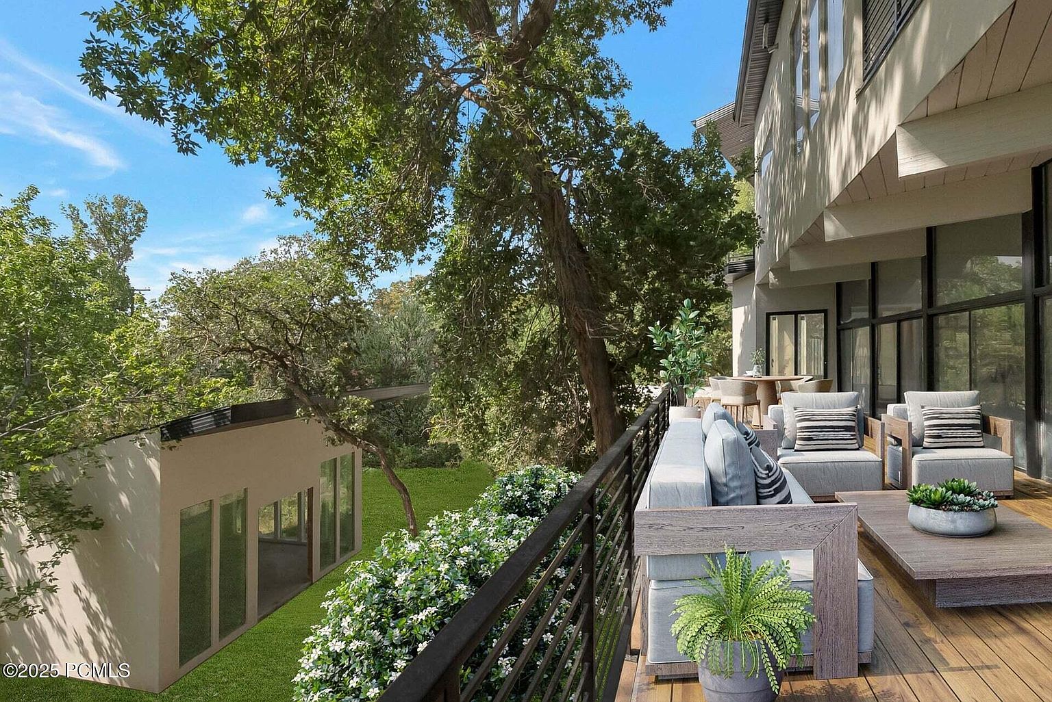 This image showcases a beautifully designed outdoor living space on a balcony or deck. The area features comfortable seating arrangements with stylish cushions and pillows, complemented by lush greenery and potted plants. The deck offers a serene view of the surrounding landscape, creating an inviting and relaxing atmosphere.