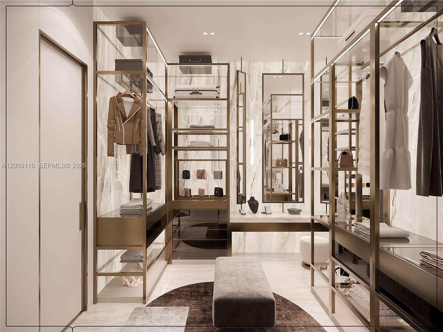 This luxurious walk-in closet features custom metal-framed shelving with integrated lighting and a sophisticated stone-clad wall backdrop. A central upholstered bench sits atop a circular rug, providing a refined focal point within the symmetrical layout. The space is accented by tall mirrors and high-end finishes, creating an elegant and organized boutique-style atmosphere.