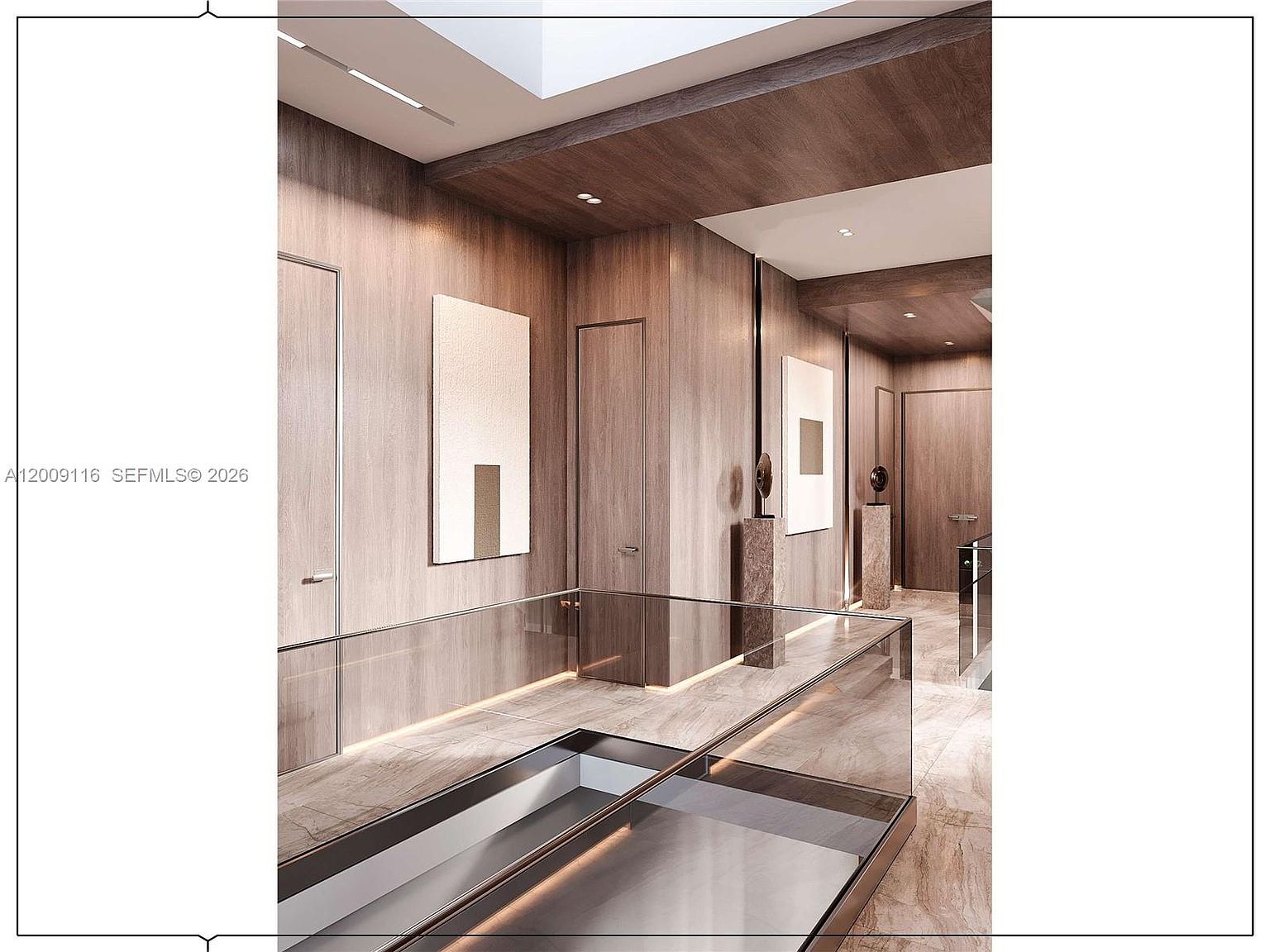 This sophisticated interior hallway features warm-toned wood paneling on the walls and a polished stone floor. A glass railing overlooks a lower level, while recessed lighting and a skylight create a bright, airy atmosphere. The space is accented with minimalist artwork and sculptural pedestals, conveying a modern and luxurious aesthetic.