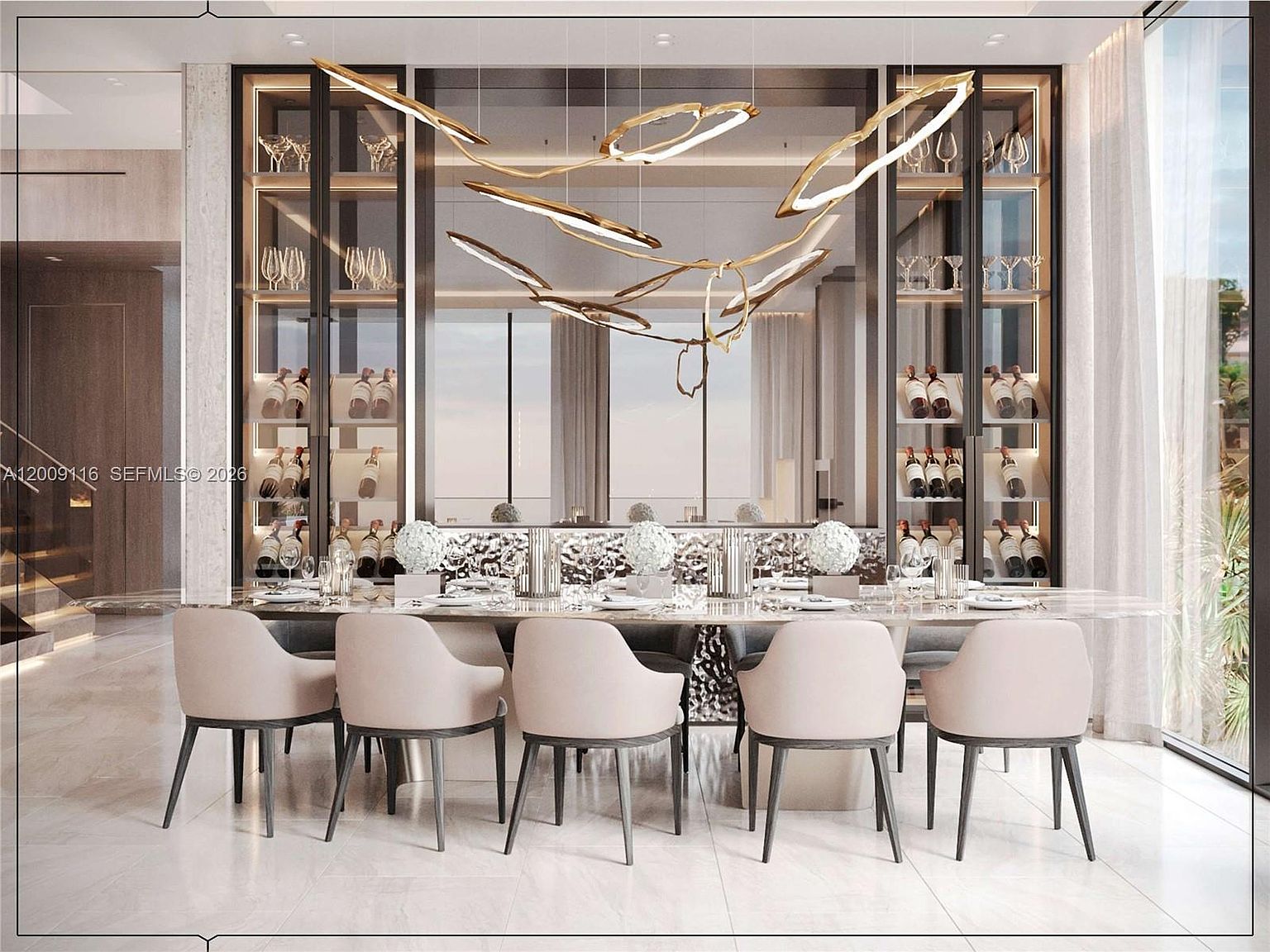 This sophisticated dining room features a long, sleek table surrounded by five upholstered chairs with dark wooden legs. A striking, sculptural gold-toned chandelier hangs above the table, serving as a focal point against the backdrop of a mirrored wall with integrated glass-front wine storage cabinets. The room is finished with light-colored stone flooring and large windows to the right, creating an elegant and airy atmosphere.