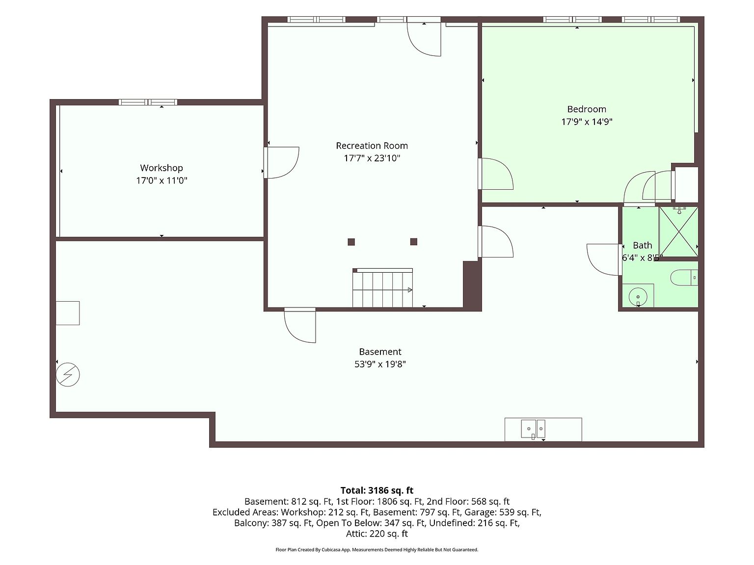 This image is a detailed 2D floor plan of a basement level, showcasing a layout that includes a large recreation room, a bedroom, a bathroom, and a workshop area. The diagram provides precise dimensions for each room and indicates the location of stairs, doors, and windows. It serves as a technical architectural document to help potential buyers understand the spatial configuration and flow of the lower level.