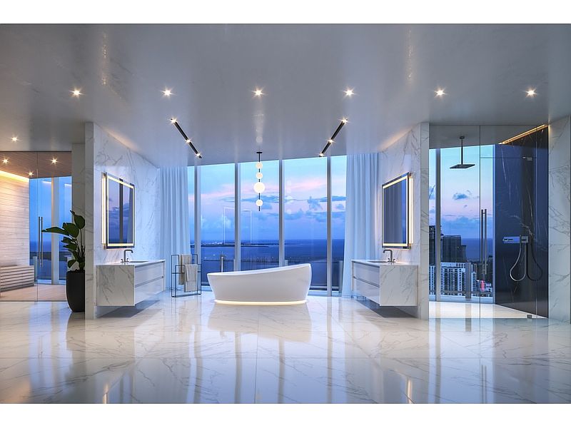 This is a luxurious primary bathroom featuring a freestanding bathtub as a focal point, flanked by large windows offering a stunning view. The bathroom includes dual vanities with modern fixtures, a glass-enclosed shower, and marble flooring, creating a spa-like atmosphere. The perspective is wide, showcasing the spaciousness and high-end finishes.