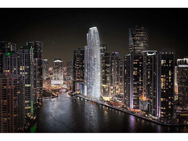 This aerial view showcases a stunning cityscape at night, dominated by illuminated skyscrapers and a winding river reflecting the city lights. The modern architecture and vibrant urban environment create a sense of luxury and sophistication. The image highlights the prime waterfront location and the impressive scale of the buildings.