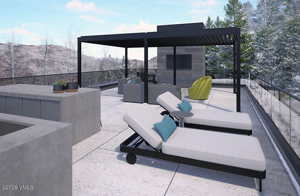 This image showcases a modern outdoor patio or deck area, featuring sleek lounge chairs with blue pillows, a contemporary pergola, and comfortable outdoor seating. The space is designed for relaxation and entertainment, with a built-in outdoor kitchen area and a view of the surrounding landscape. The overall impression is one of luxury and sophisticated outdoor living.