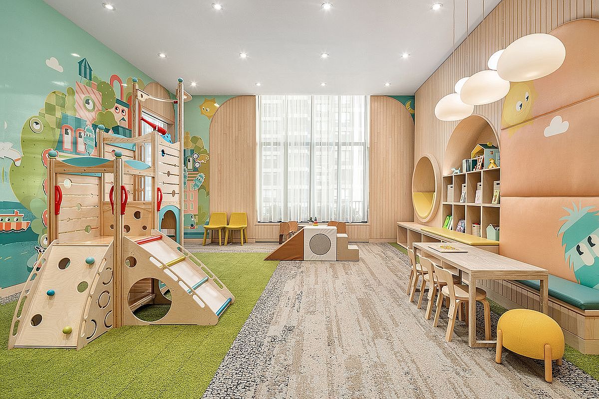 This vibrant, modern children's playroom features a whimsical design with a wooden climbing structure, a slide, and a dedicated reading nook with built-in shelving. The space is brightly lit with recessed lighting and unique cloud-shaped pendant lights, creating a welcoming and playful atmosphere. The room is finished with a mix of green carpet and neutral-toned flooring, complemented by soft, pastel-colored wall murals and comfortable seating.