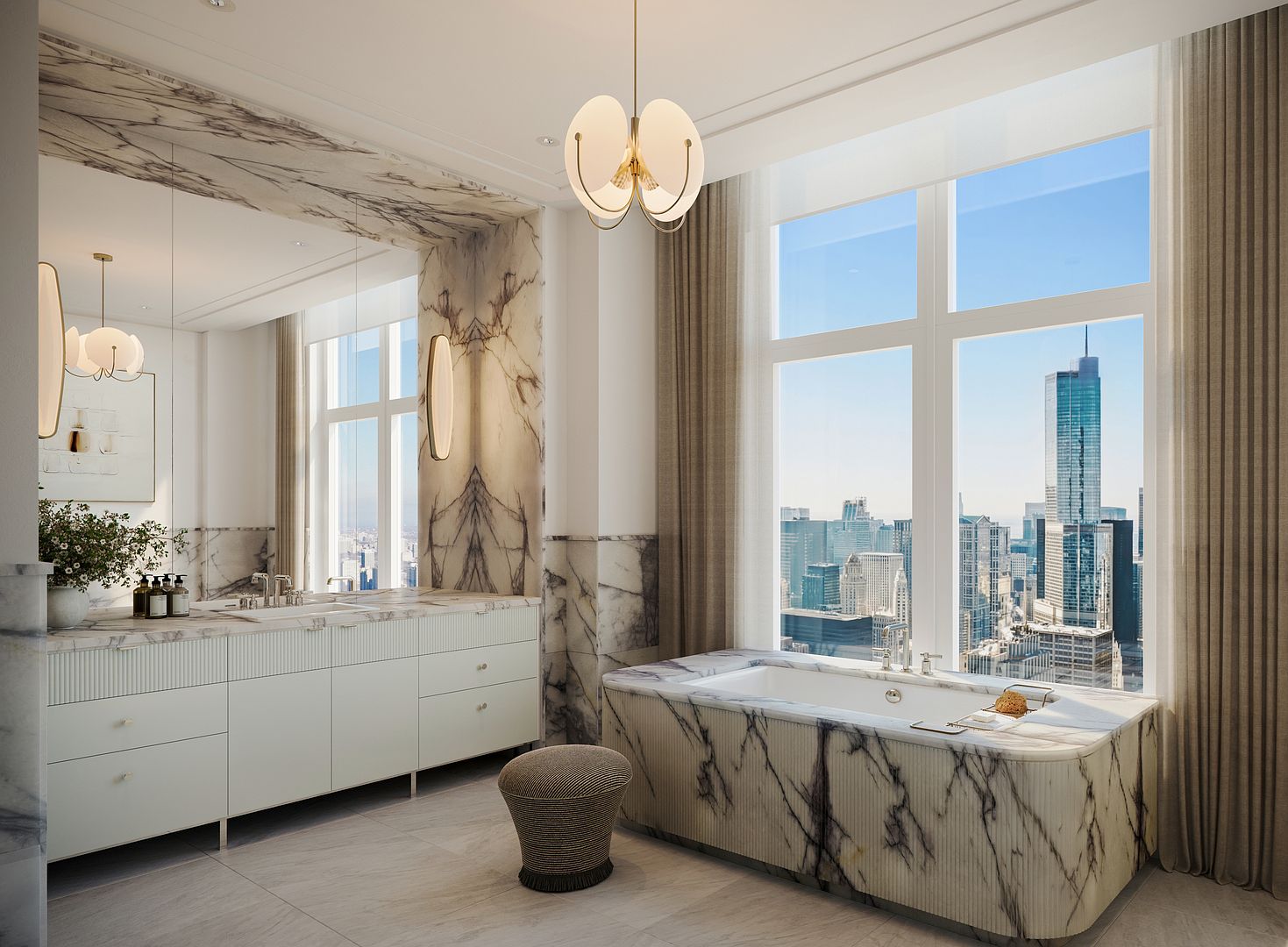 This luxurious primary bathroom features a deep soaking tub encased in patterned stone, positioned perfectly to take advantage of the expansive city skyline views through large windows. A long vanity with integrated sinks and fluted cabinetry provides ample storage, complemented by a large mirror and elegant pendant lighting. The space is finished with neutral stone flooring and wall accents, creating a sophisticated and serene atmosphere.