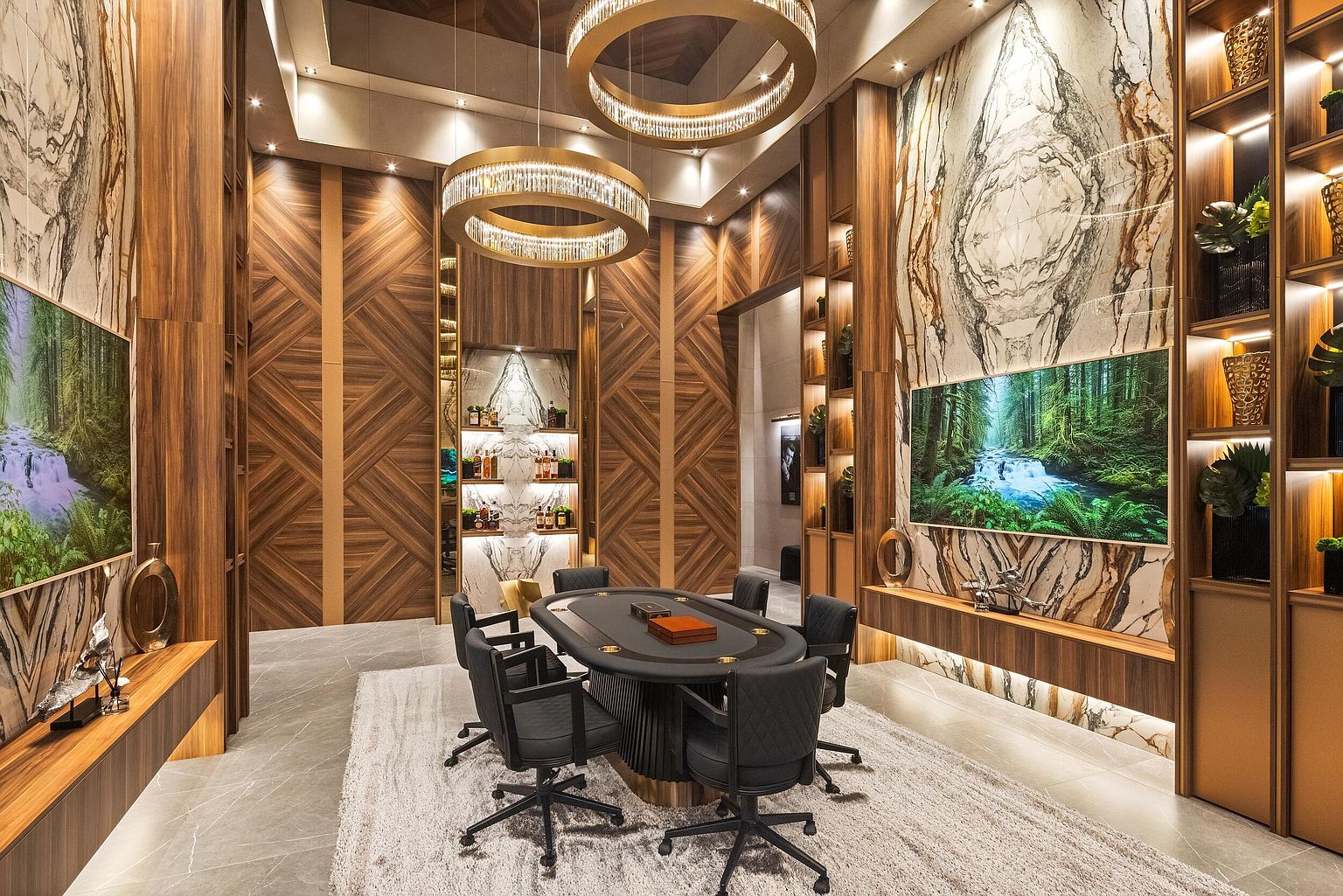 This sophisticated game or study room features a central poker table surrounded by dark leather chairs, set beneath two large, circular tiered chandeliers. The walls are adorned with intricate wood paneling and large, full-height stone slabs that frame digital displays showing forest landscapes. The room is anchored by a plush, light-colored area rug on a stone floor, creating a luxurious and immersive atmosphere.