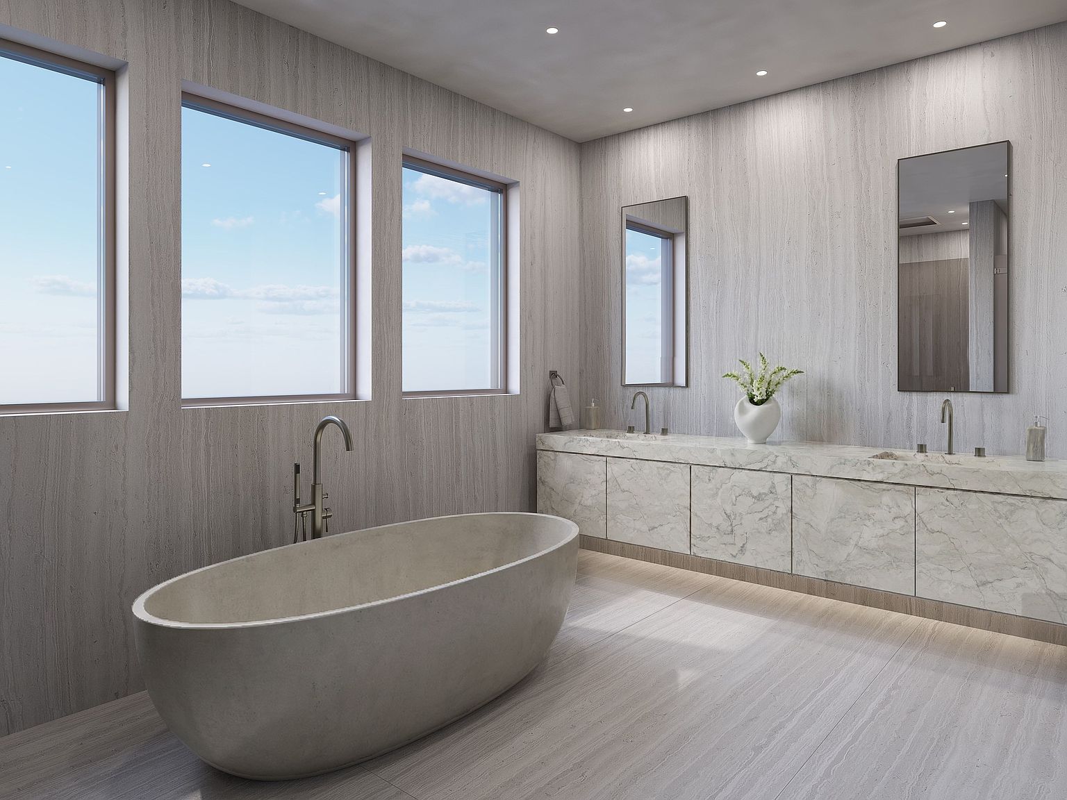 This sophisticated primary bathroom features a minimalist aesthetic with light-toned, linear-patterned wall and floor surfaces. A sculptural, oval-shaped soaking tub sits prominently in the foreground, complemented by a long, floating vanity topped with a patterned stone surface and dual sinks. Three large windows provide ample natural light and an expansive view, creating a serene and airy atmosphere.