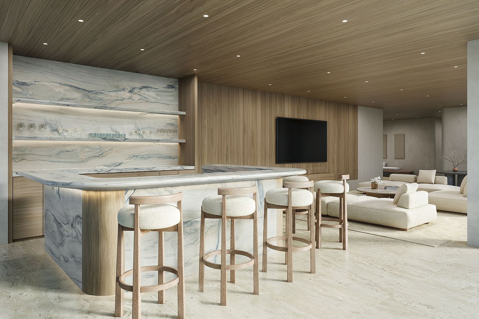 This sophisticated interior space features a prominent bar area with a curved stone counter and light wood base, complemented by four matching bar stools with cream-colored upholstery. The bar is set against a backdrop of patterned stone shelving with integrated lighting, while the adjacent living area showcases a neutral-toned sectional sofa and a wall-mounted television. The room is unified by a warm wood-paneled ceiling with recessed lighting and light-toned stone flooring, creating a cohesive and luxurious atmosphere.