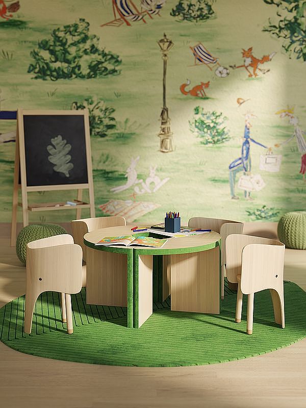 This charming children's playroom features a whimsical, nature-themed wallpaper depicting a park scene with foxes and rabbits. The room is furnished with a circular wooden table and four matching elephant-shaped chairs, set atop a vibrant green circular rug. A wooden chalkboard easel stands in the background, creating an inviting and playful space for young children.