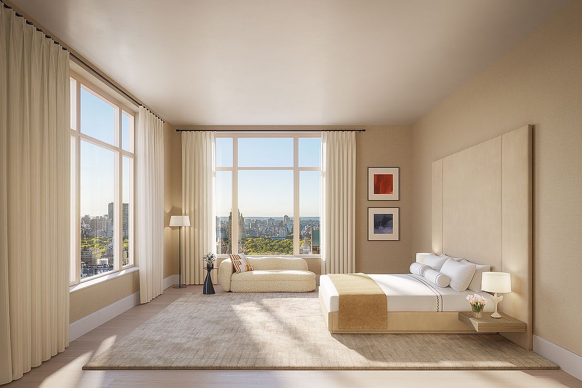 This luxurious primary bedroom features a minimalist, contemporary design with a neutral color palette and expansive floor-to-ceiling windows that offer a stunning panoramic view of a city park. The room is anchored by a large, plush area rug, a low-profile bed with a custom integrated headboard, and a stylish curved chaise lounge positioned to take advantage of the natural light. The overall atmosphere is one of serene sophistication and high-end urban living.