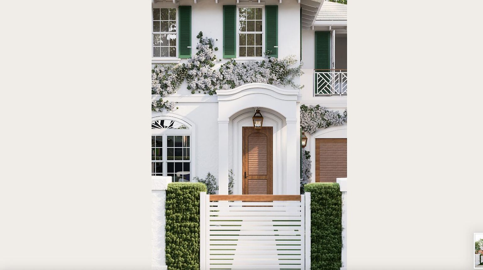 The image showcases the elegant entryway of a two-story home, featuring a wooden front door framed by white columns and an arched doorway. Lush white flowering vines cascade down the facade, complementing the green shutters on the windows. A white horizontal slat fence with green shrubbery adds privacy and curb appeal, creating a welcoming and sophisticated entrance.