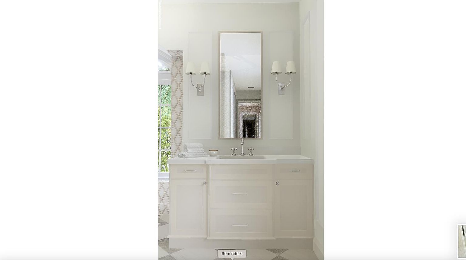 This is a well-lit bathroom featuring a vanity with a white countertop and cabinetry. A rectangular mirror hangs above the sink, flanked by sconce lighting. The room has a clean and classic design, with neutral tones and a window providing natural light.