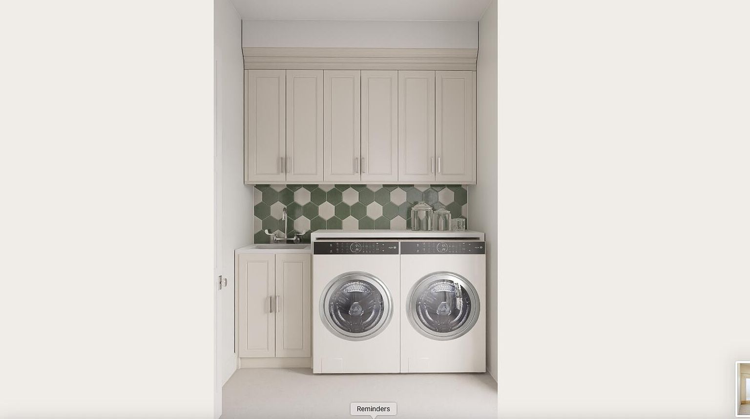 This is an interior shot of a laundry room featuring a stacked washer and dryer set, light-colored cabinetry above and to the left of the appliances, and a green and white hexagonal tile backsplash. The room is well-lit and appears clean, suggesting a functional and organized space for laundry tasks.