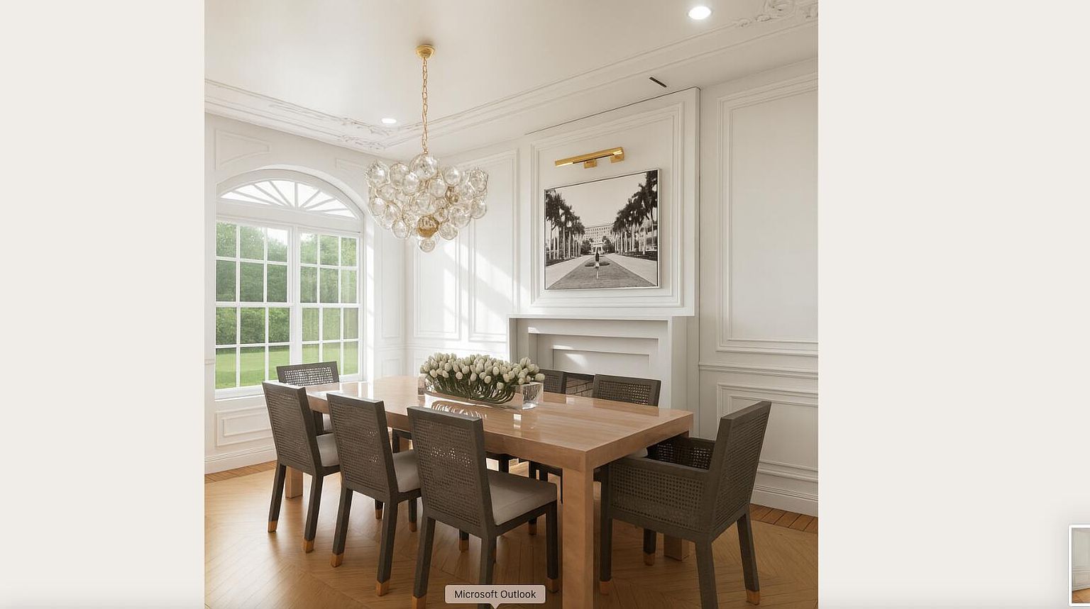 This is an interior shot of a dining room featuring a wooden table with six chairs. A floral centerpiece sits on the table, and a chandelier hangs above. The room is decorated in a classic style with white walls, detailed molding, and a large window providing natural light.
