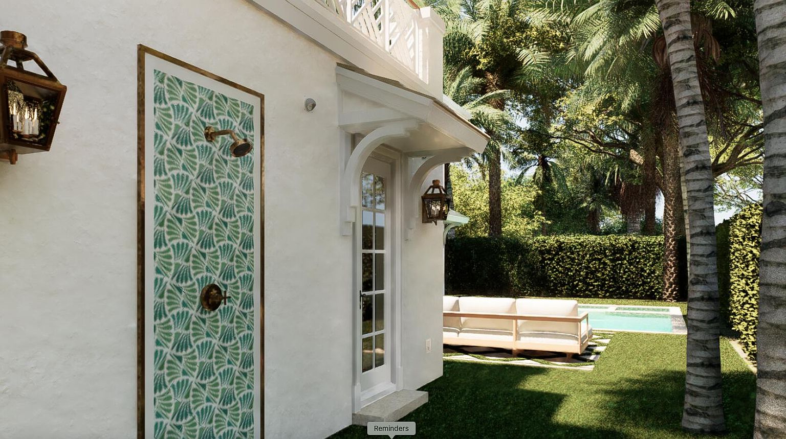 This image showcases a luxurious outdoor space featuring an outdoor shower with a decorative tile panel, a well-manicured lawn, and a glimpse of a swimming pool. A stylish outdoor sofa is visible in the background, suggesting a comfortable lounging area. The scene is framed by lush greenery and palm trees, creating a tropical and serene atmosphere.