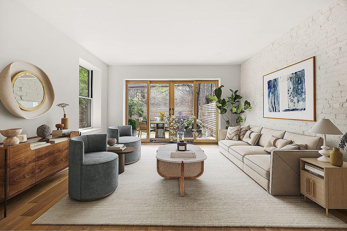 This is a bright and airy living room featuring a neutral color palette with hardwood floors and a large area rug. The room is furnished with a comfortable sectional sofa, two round armchairs, and a stylish coffee table. A large sliding glass door leads to an outdoor space, and artwork adorns the walls, creating a sophisticated and inviting atmosphere.