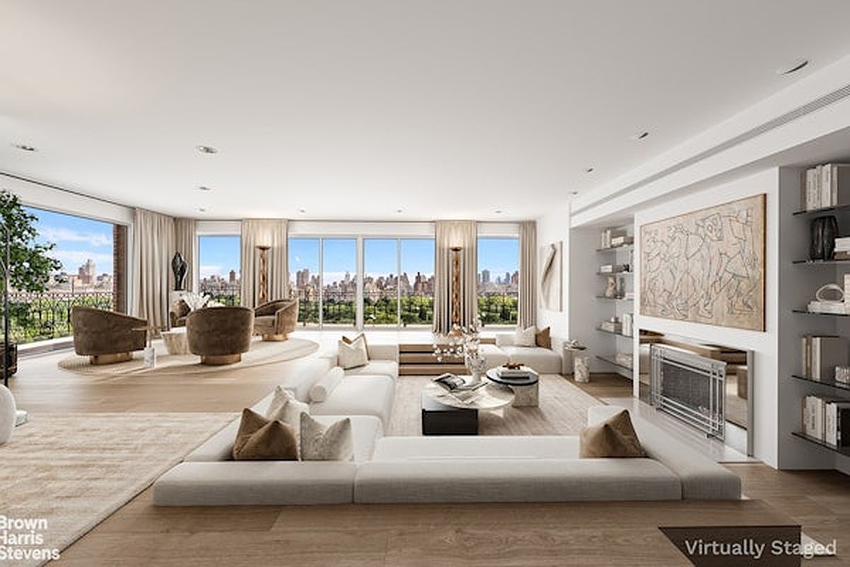 This expansive, open-concept living room features a sophisticated, neutral color palette and a large, modular sectional sofa as the central seating area. The space is defined by light wood flooring and a wall of floor-to-ceiling windows that provide panoramic city and park views, while a sleek fireplace with a metallic surround serves as a focal point on the adjacent wall. Built-in shelving and a large piece of abstract art add character to the room, which is bathed in natural light and exudes a luxurious, airy atmosphere.