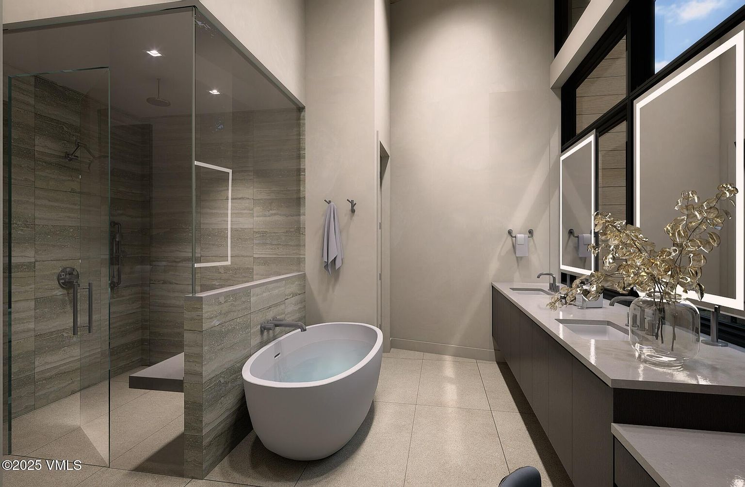 This is a modern primary bathroom featuring a glass-enclosed shower with a built-in bench, a freestanding soaking tub, and a long vanity with dual sinks and illuminated mirrors. The color palette is neutral, with beige walls and gray cabinetry, creating a serene and spa-like atmosphere. Large windows provide natural light, enhancing the luxurious feel of the space.