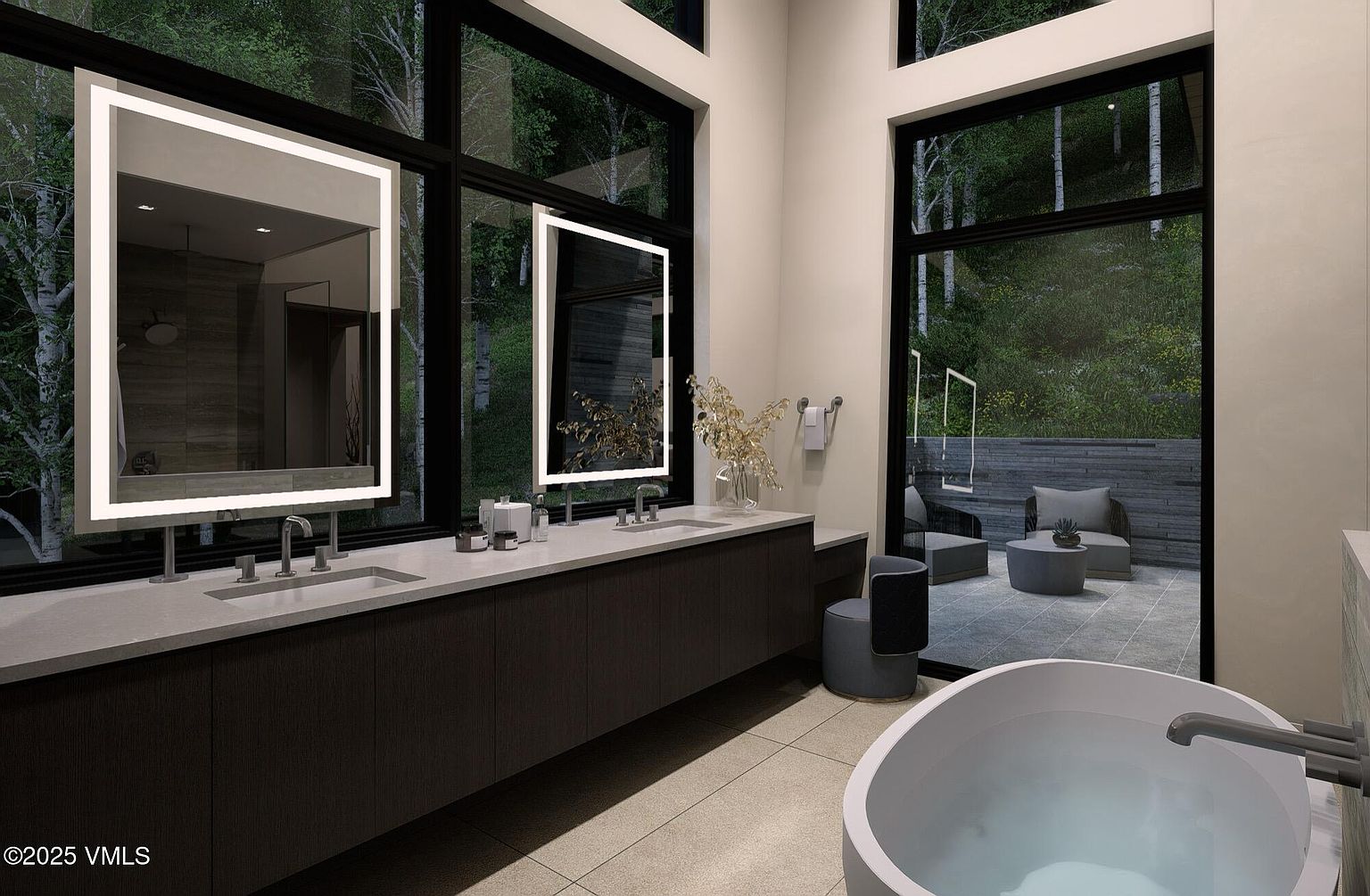 This is a luxurious primary bathroom featuring a modern aesthetic with clean lines and natural light. The room boasts a long vanity with dual sinks, illuminated mirrors, and dark wood cabinetry. Large windows offer a view of the surrounding greenery, and a freestanding bathtub adds a spa-like touch. A small outdoor patio with seating is visible through the windows, enhancing the sense of tranquility and connection to nature.