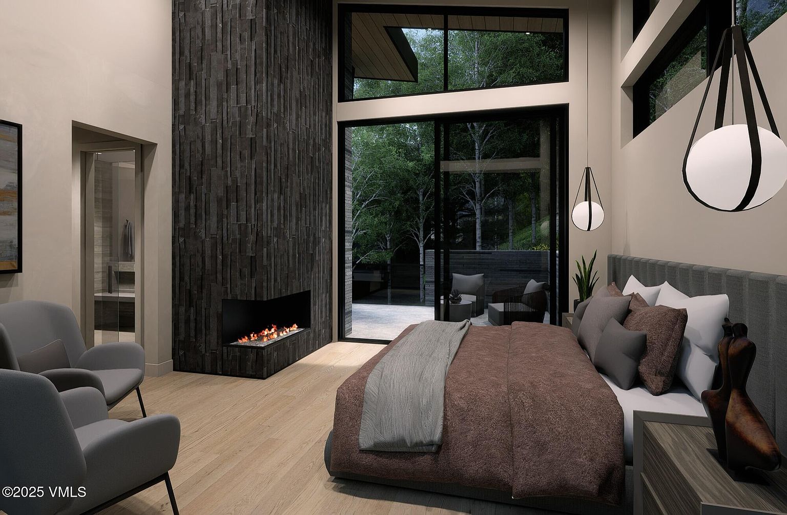 This is a primary bedroom featuring a modern fireplace with a dark stone surround, a large bed with a brown comforter and gray throw, and floor-to-ceiling windows offering a view of the outdoors. The room is decorated in neutral tones with gray armchairs, creating a serene and luxurious atmosphere. The perspective is from the foot of the bed, looking towards the fireplace and windows.
