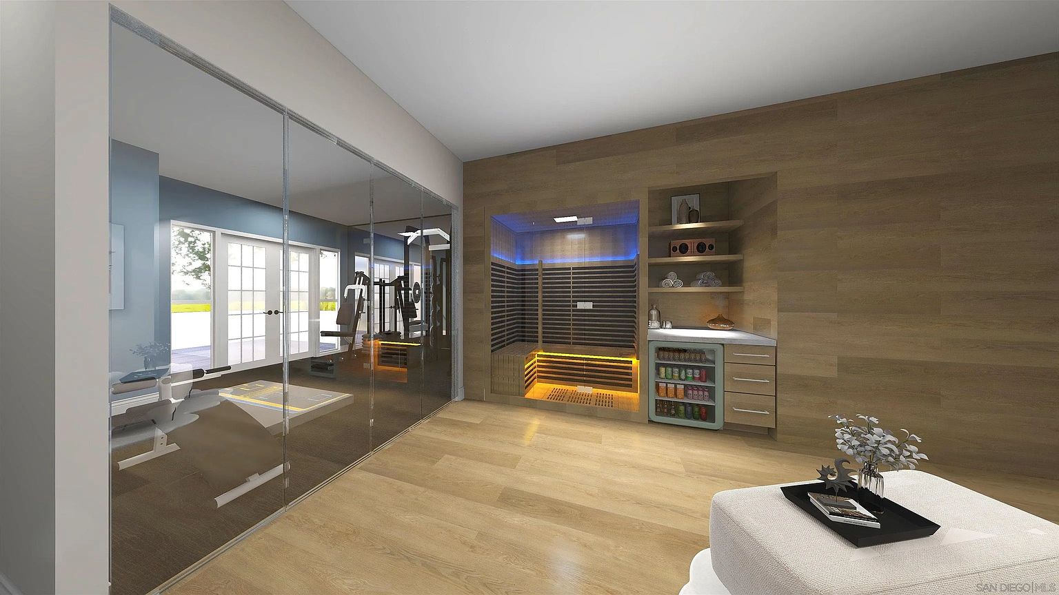 This is an interior shot of a home gym featuring a sauna, exercise equipment, and a beverage refrigerator. The room has wood flooring and a large glass wall separating the gym area from the sauna and storage area. The sauna is illuminated with blue and orange lights, adding a modern touch to the space.