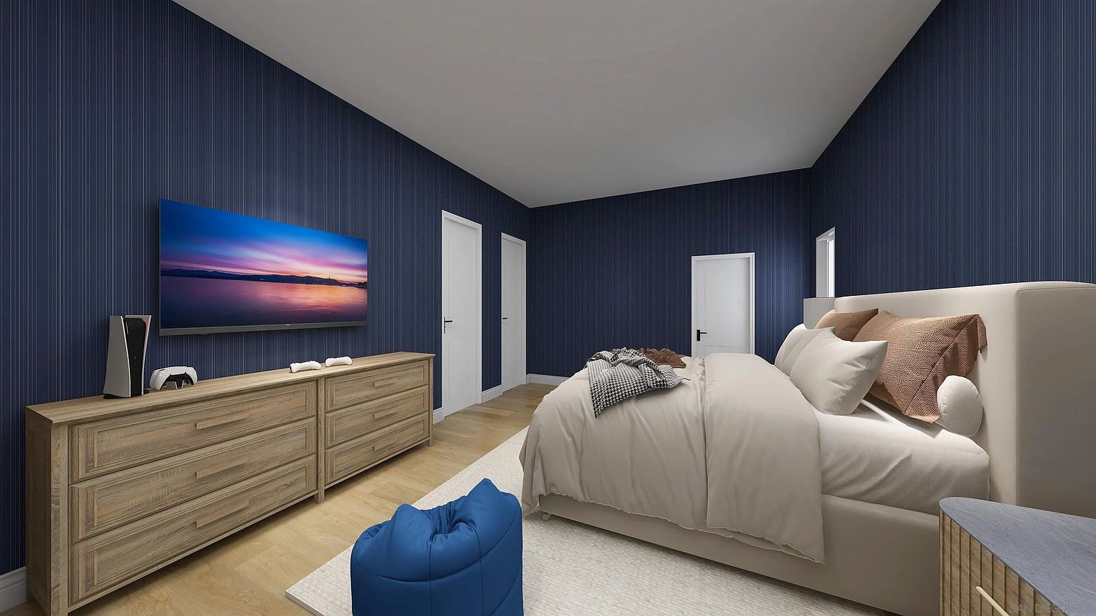 This is a primary bedroom featuring a large bed with neutral bedding, a wooden dresser with a TV mounted above it, and a blue beanbag chair. The walls are covered in a dark blue striped wallpaper, and the flooring is light wood. The room has a modern and comfortable feel, suitable for relaxation and entertainment.