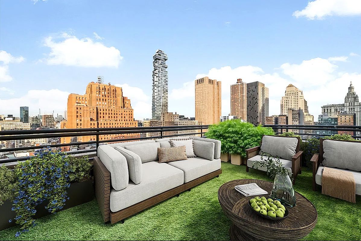 This high-rise balcony offers a sophisticated outdoor living space with a panoramic view of the city skyline. The area is furnished with a modern, neutral-toned sofa and matching armchairs arranged on artificial turf, complemented by a rustic wooden coffee table and lush potted greenery. The setting provides an elegant and serene urban retreat, perfect for entertaining or relaxing while overlooking the dense metropolitan architecture.