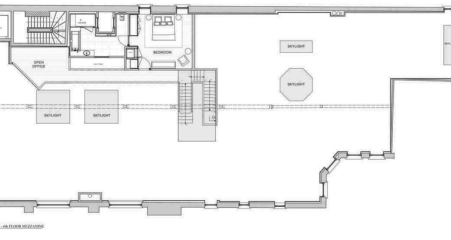This image is a detailed architectural floor plan for a 6th-floor mezzanine level. The layout features an open office area, a bedroom with an en-suite bathroom, a central staircase, and a large, expansive open space punctuated by multiple skylights. The drawing provides a clear top-down perspective of the spatial arrangement and structural flow of the floor.