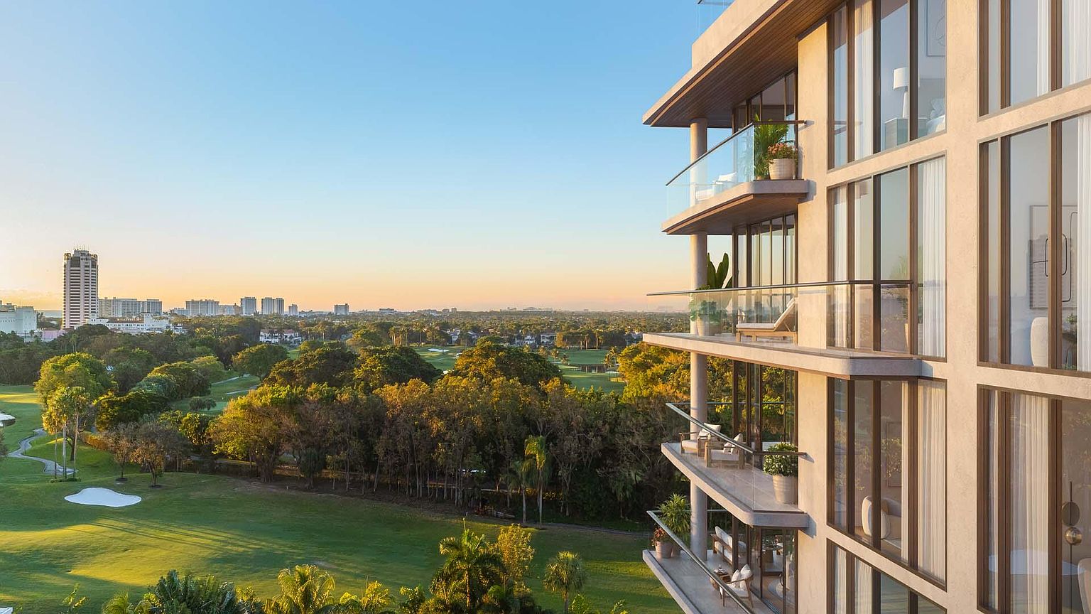This image showcases the side of a modern residential building with multiple balconies overlooking a lush green golf course and a distant cityscape. The building features clean lines, large windows, and glass railings, creating a sense of luxury and openness. The view from the balconies offers a desirable amenity for potential residents.