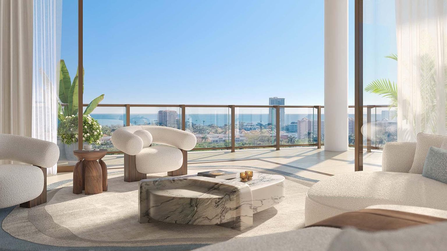 This is a luxurious living room with a modern design, featuring plush white seating, a unique marble coffee table, and a stylish wooden side table. Large windows offer a stunning view of the ocean and cityscape, creating a bright and airy atmosphere. The space is elegantly furnished and designed for comfort and sophistication.