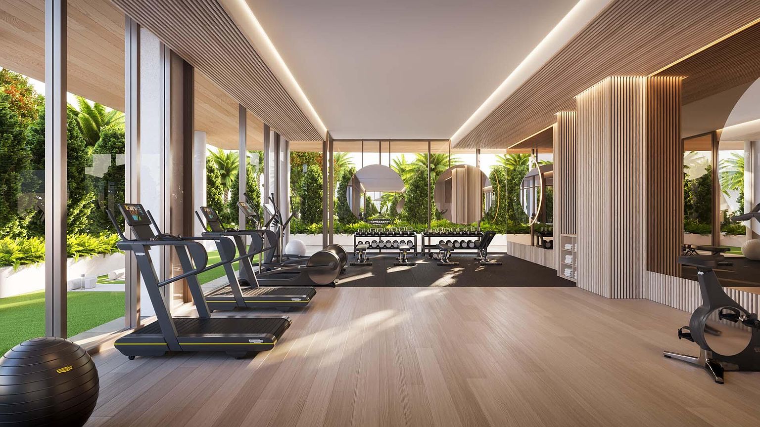This is a well-lit, modern home gym featuring state-of-the-art equipment such as treadmills, elliptical machines, and free weights. Large windows offer views of lush greenery, creating a serene workout environment. The space is designed with a wood floor and a wood-slatted ceiling with recessed lighting, enhancing the luxurious feel.