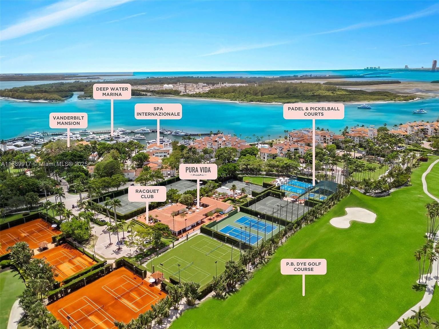 This aerial view showcases a luxurious waterfront community with a deep water marina, Vanderbilt Mansion, and Spa Internazionale. The property boasts a variety of amenities including racquet club, Pura Vida, paddle and pickleball courts, and a P.B. Dye golf course. The overall impression is one of exclusivity and high-end resort living.