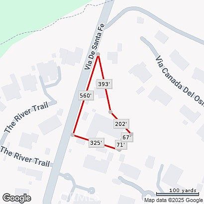 This aerial view showcases a property outlined in red, highlighting its boundaries and dimensions. The image includes labeled measurements along the property lines, providing a clear understanding of the lot's size and shape in relation to nearby streets and trails. The surrounding area features residential buildings and natural elements, offering context to the property's location.