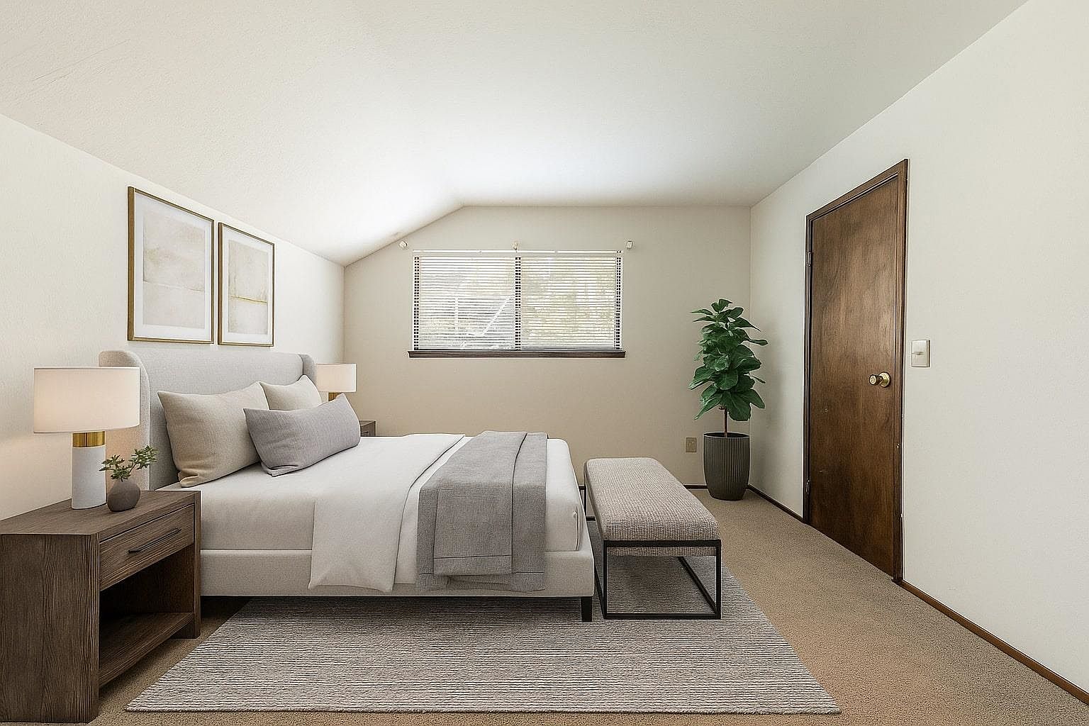 This is a well-staged primary bedroom featuring a neutral color palette. The room includes a bed with a padded headboard, side tables with lamps, and artwork on the wall. A bench sits at the foot of the bed, and a window provides natural light. The perspective is from the foot of the bed, looking towards the headboard and window.
