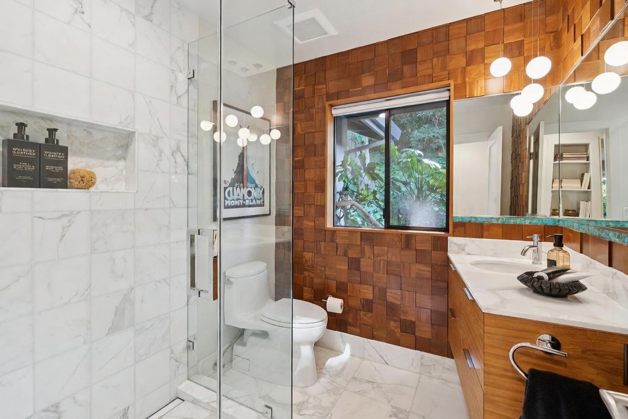 This modern bathroom features a striking contrast between white marble-tiled shower walls and warm, textured wood-block wall paneling. A glass-enclosed shower, a sleek vanity with a marble countertop, and a large mirror create a sophisticated and airy atmosphere. The space is well-lit by contemporary globe pendant lights, offering a luxurious and spa-like aesthetic.