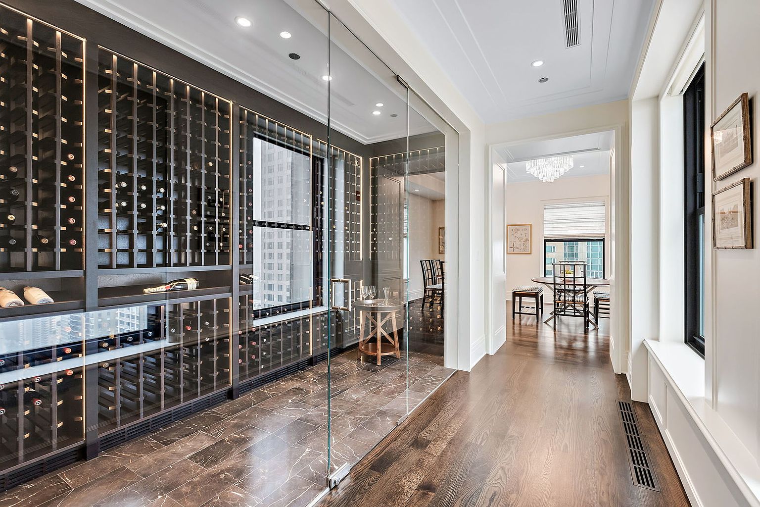 This image showcases a sophisticated wine cellar with a modern design. The cellar features extensive wine racks, a glass enclosure, and elegant marble flooring. The space is well-lit, highlighting the wine collection and creating an inviting atmosphere, perfect for showcasing the home's luxury features.