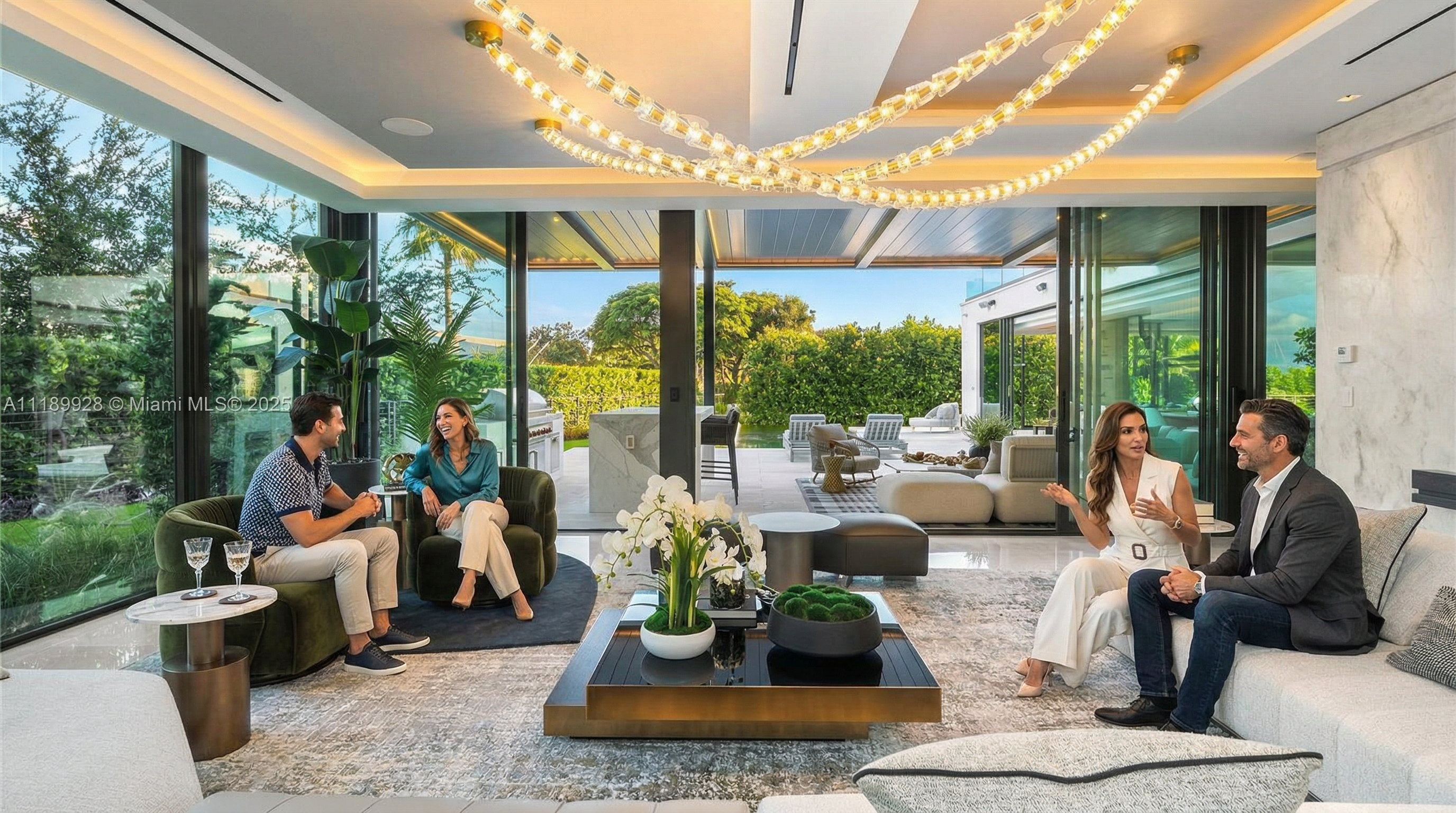 This is a luxurious living room featuring floor-to-ceiling windows that offer a seamless transition to the outdoor space. The room is furnished with modern sofas, armchairs, and a stylish coffee table, all set on a large area rug. An elaborate lighting fixture hangs from the ceiling, adding a touch of elegance to the space.