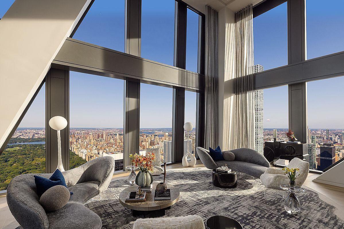 This is a luxurious living room with floor-to-ceiling windows offering panoramic city views. The room features modern, curved furniture, including plush sofas and unique coffee tables, set on a patterned rug. The design emphasizes natural light and a sophisticated, open feel, perfect for showcasing high-end living.