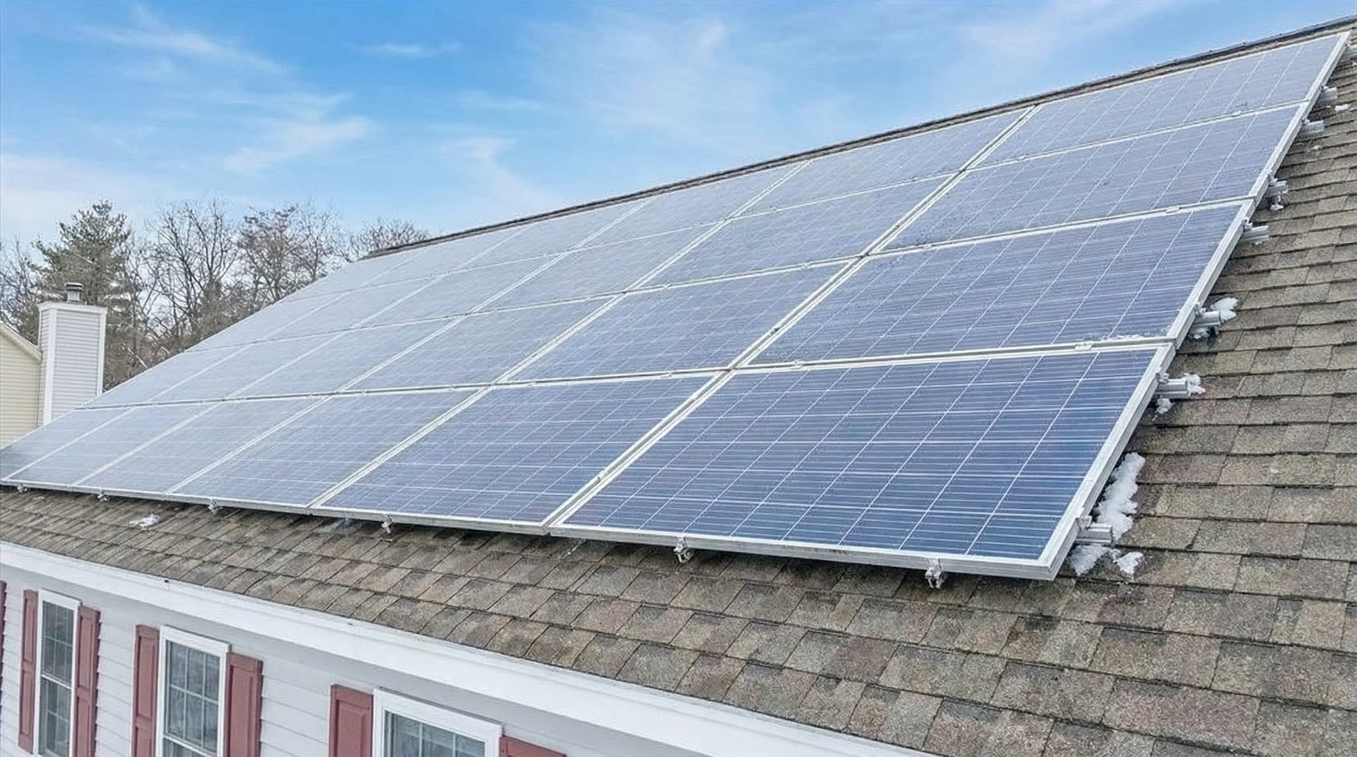 The image showcases a house's roof fitted with solar panels. The panels are neatly arranged, covering a significant portion of the roof's surface. This feature offers prospective buyers an eco-friendly, energy-efficient home upgrade.