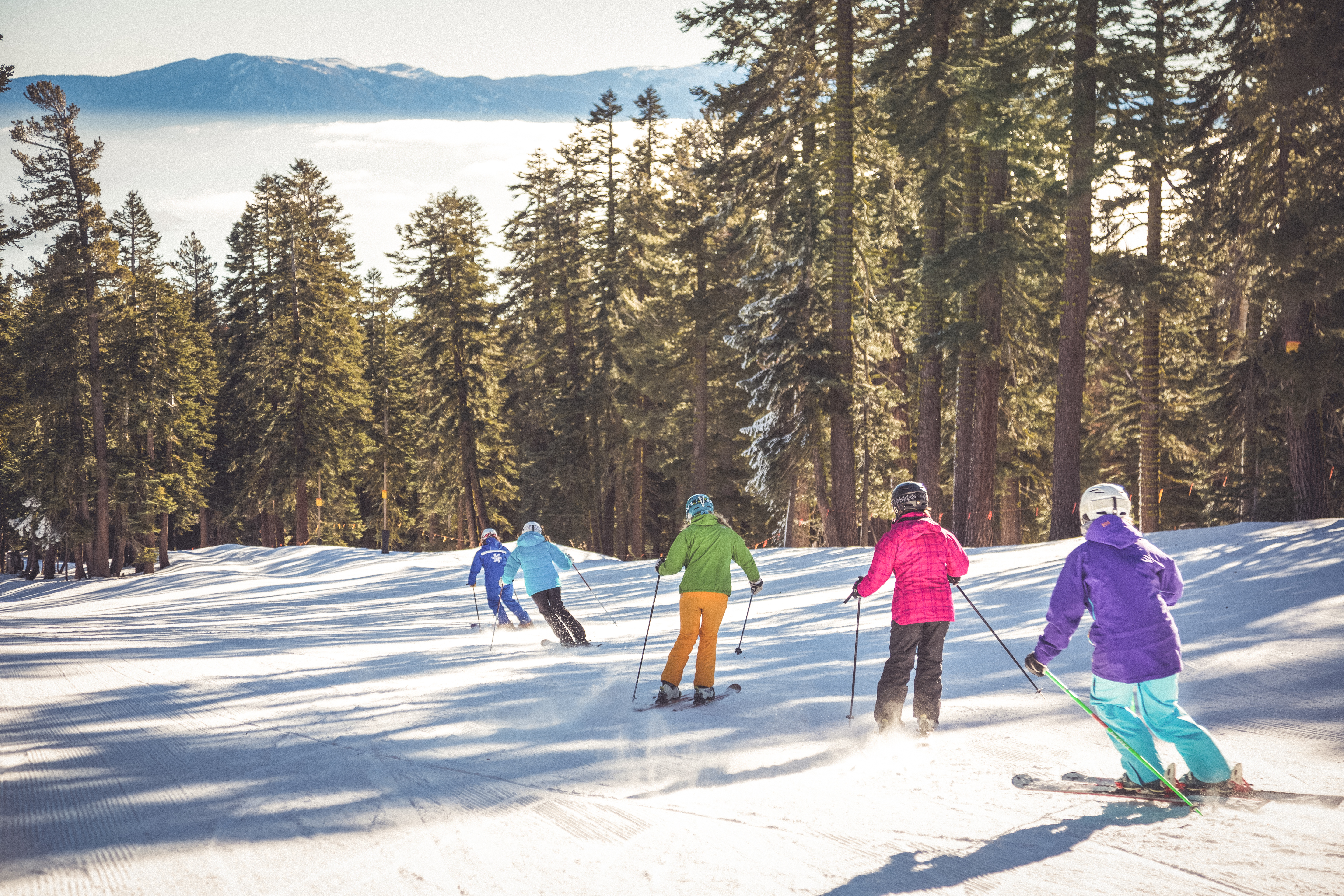 This image portrays a group of people skiing, showcasing a recreational amenity or activity associated with the real estate. The landscape features snowy slopes, trees, and distant mountains, highlighting the potential for outdoor lifestyle opportunities in the area. It emphasizes the leisure aspect and desirable location for prospective buyers.
