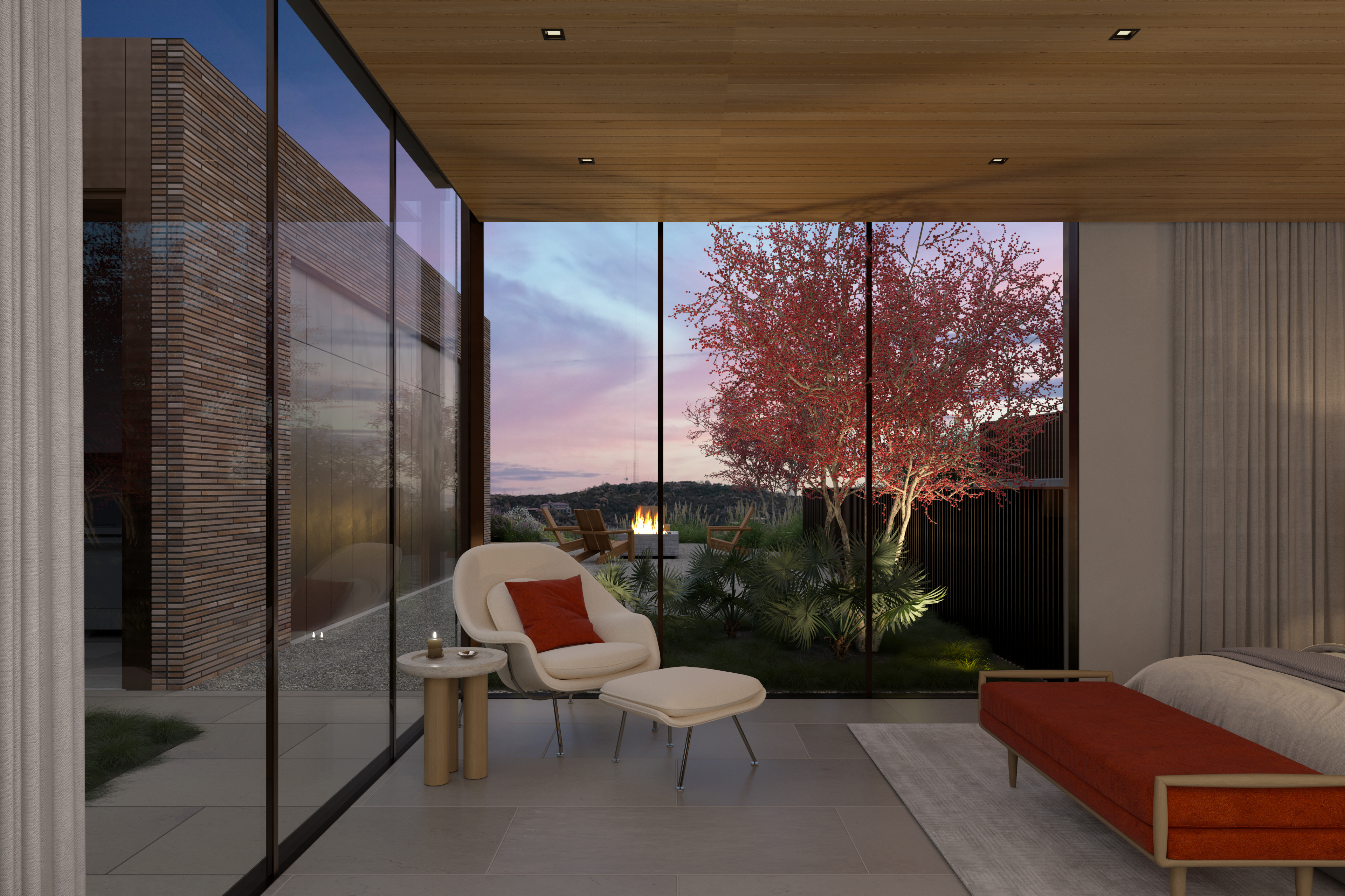This luxurious, contemporary primary bedroom features floor-to-ceiling glass walls that seamlessly connect the indoor space to a private courtyard with a fire pit. The room is elegantly furnished with a modern armchair and footstool, a vibrant orange bench at the foot of the bed, and warm wooden ceiling accents. The serene atmosphere is highlighted by the sunset views, creating a sophisticated and tranquil indoor-outdoor living experience.