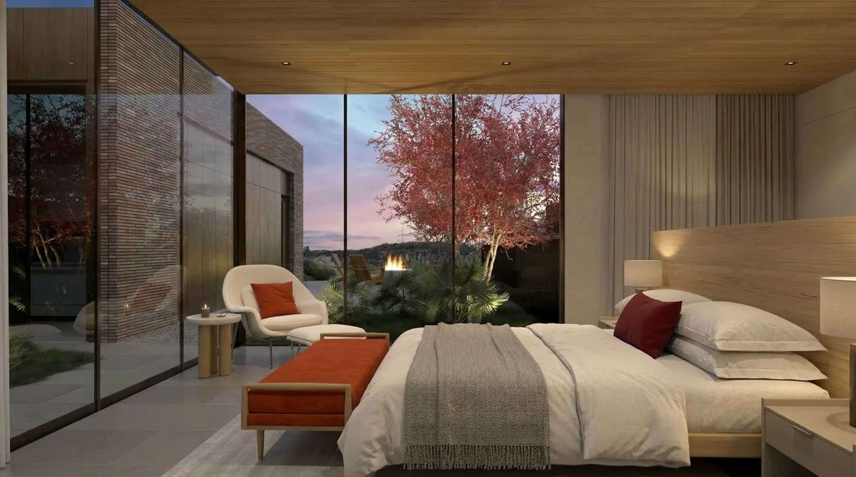 This modern, luxury primary bedroom features high-end finishes, clean lines, and an expansive floor-to-ceiling glass wall that offers seamless views of a private outdoor space. The room is anchored by a sophisticated minimalist bed with neutral bedding, a bold accent bench, and a comfortable reading chair, all set against a warm wood-paneled ceiling. The space conveys an atmosphere of serene, high-end comfort, blending indoor elegance with natural beauty.