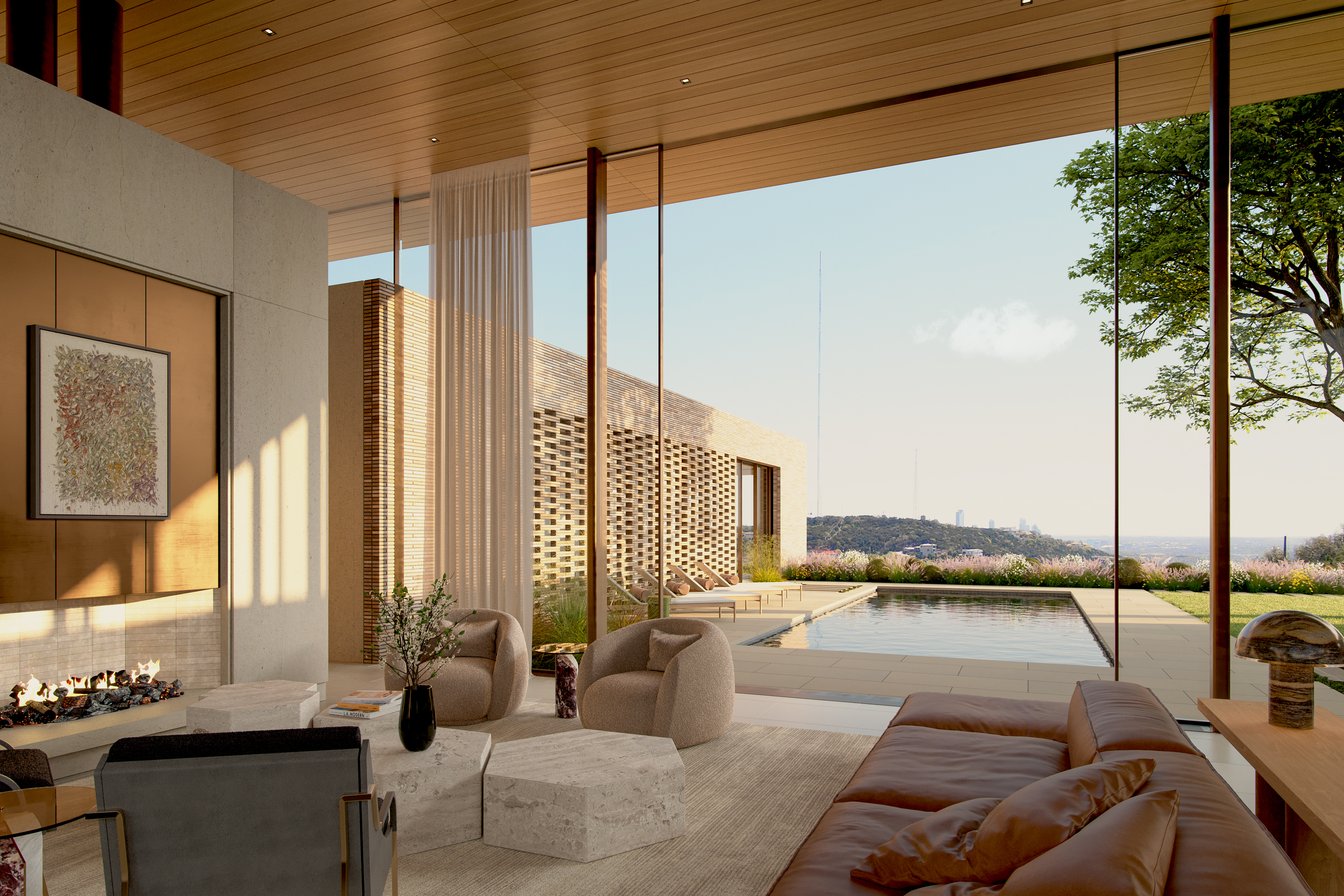 This sophisticated luxury living space features an open-concept design that seamlessly blends the indoors with the outdoors through expansive floor-to-ceiling glass walls. The room is anchored by a fireplace with a distinct art piece, plush neutral-toned armchairs, a leather sofa, and a stone-topped coffee table, all overlooking a serene private swimming pool and a landscaped terrace. With its warm wood ceiling, ambient lighting, and panoramic views of the surrounding hills, the space exudes a refined, contemporary elegance.