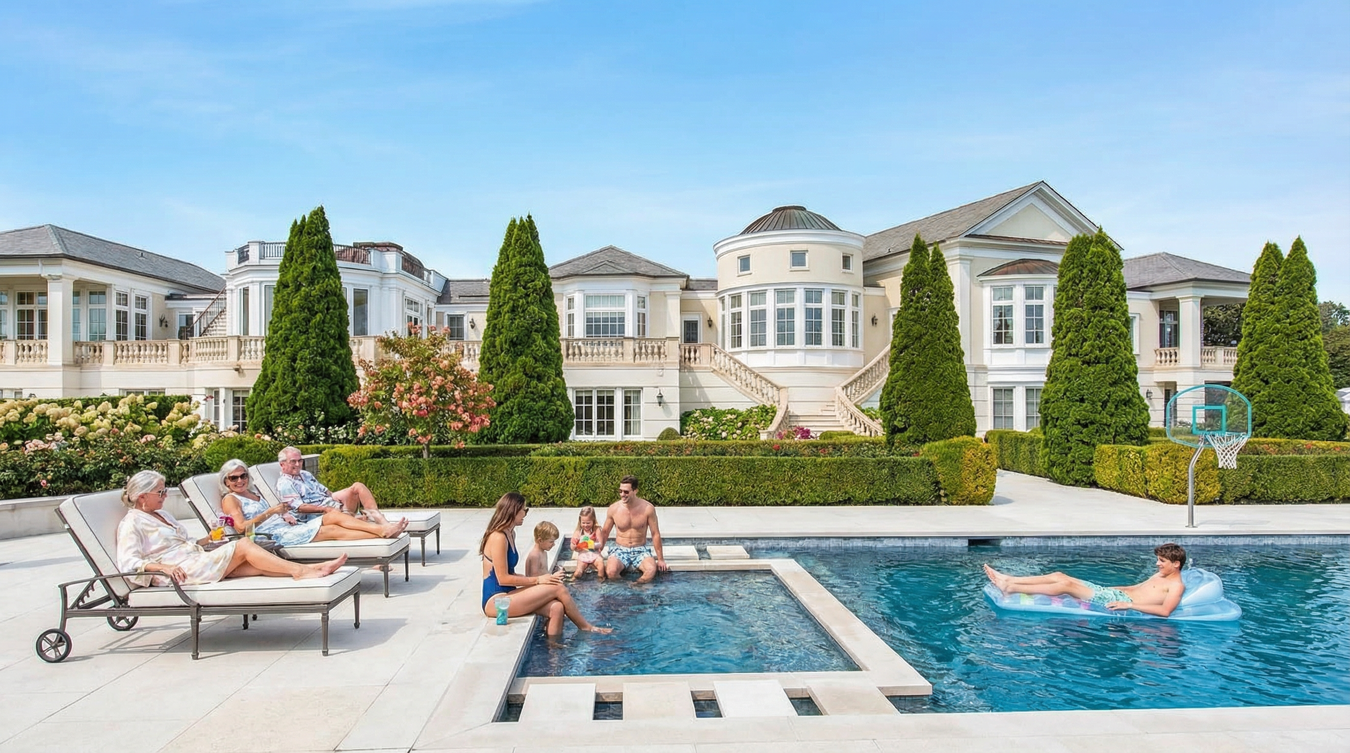 This image showcases a luxurious pool and spa area in the backyard of a grand estate. Several people can be seen enjoying features of the outdoor amenities. Verdant landscaping and mature trees provide privacy and complement the elegant architecture of the home, creating a resort-like atmosphere.