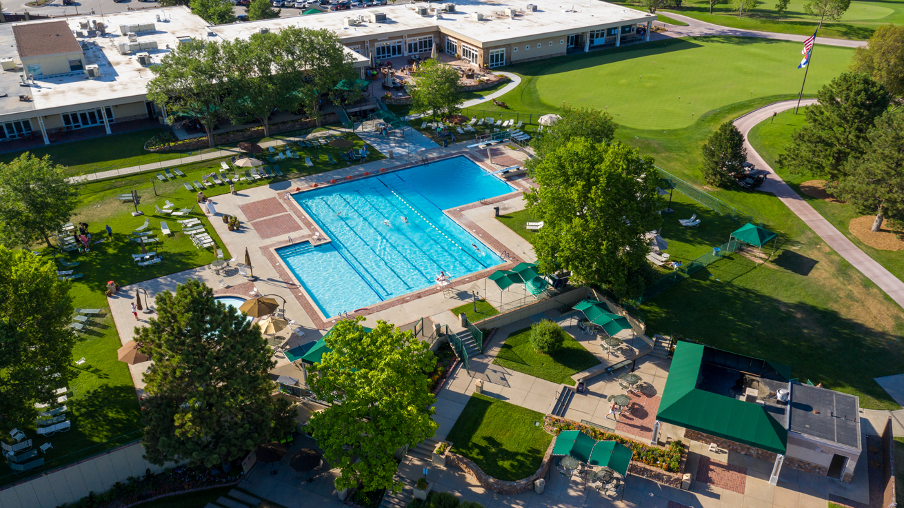 This aerial shot showcases a meticulously maintained outdoor recreation area. A large swimming pool is the focal point, surrounded by lounge chairs and landscaping. The image emphasizes the upscale amenities and leisure opportunities associated with this property.