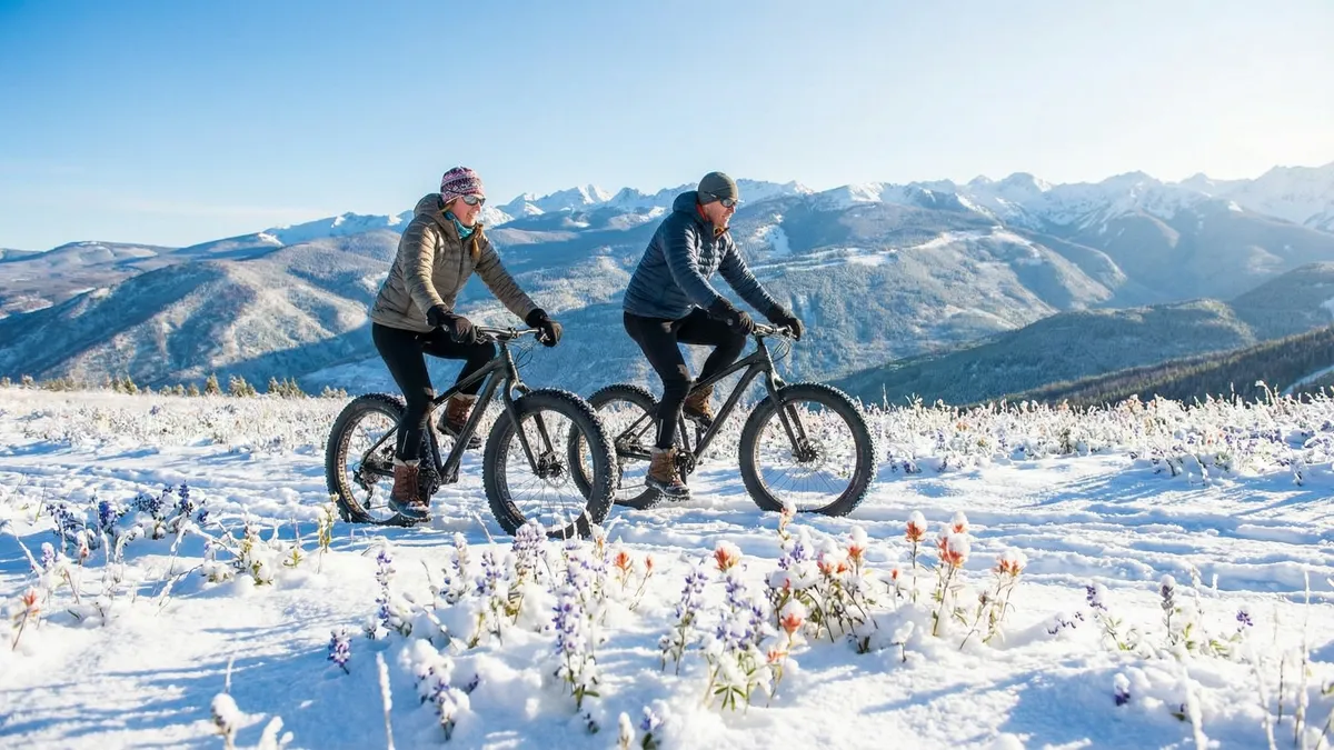 This photo features two individuals enjoying winter fat bike riding amidst a snowy landscape. The backdrop showcases majestic, snow-covered mountains. The scene evokes a sense of outdoor adventure and portrays the surrounding area as a recreational destination, potentially increasing the property's value in terms of lifestyle and access to nature.