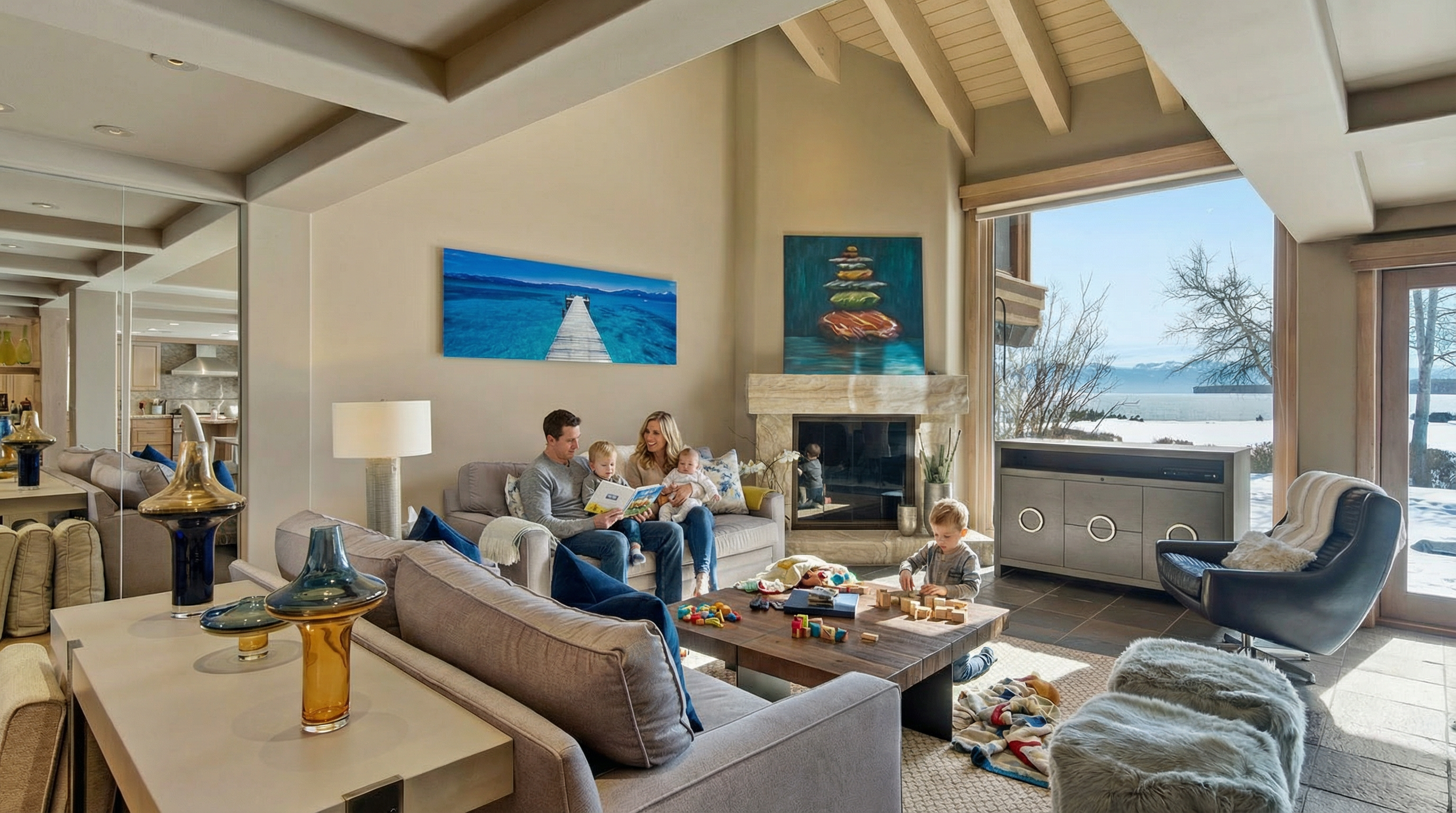 The image showcases a bright and airy living room with a high vaulted ceiling featuring wooden beams. The room is tastefully decorated with neutral-toned sofas, colorful artwork, and modern furnishings. A large window offers a stunning view of the landscape, enhancing the overall appeal and creating a warm, inviting atmosphere.