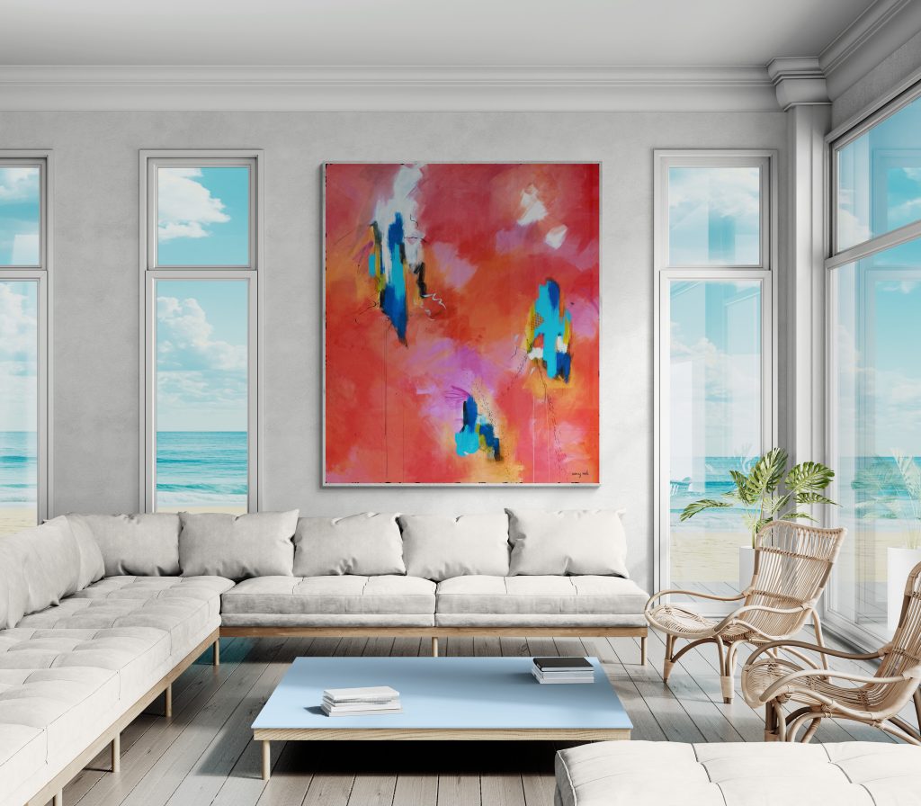 This bright and airy living room features an expansive, contemporary sectional sofa arranged around a sleek, light blue coffee table. A large, vibrant abstract painting serves as a bold focal point on the wall, while floor-to-ceiling windows provide stunning panoramic views of the ocean and beach. The space is decorated in a minimalist style with natural textures and light tones, creating an inviting and peaceful coastal atmosphere.